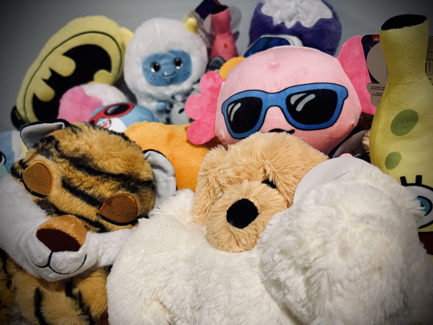 A pile of colorful plush stuffies won from claw machines